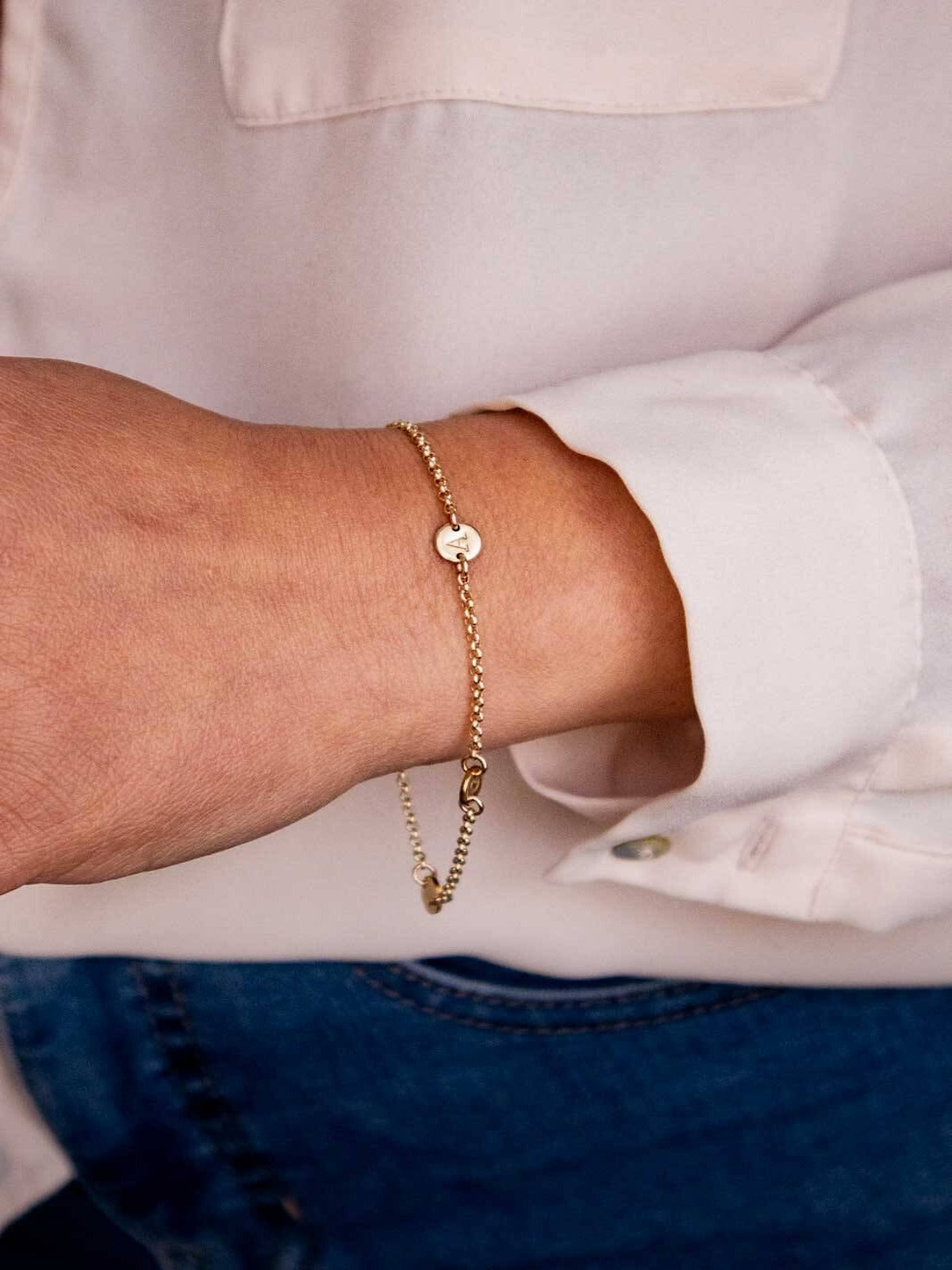 Gold bracelet personalised with letter worn on wrist
