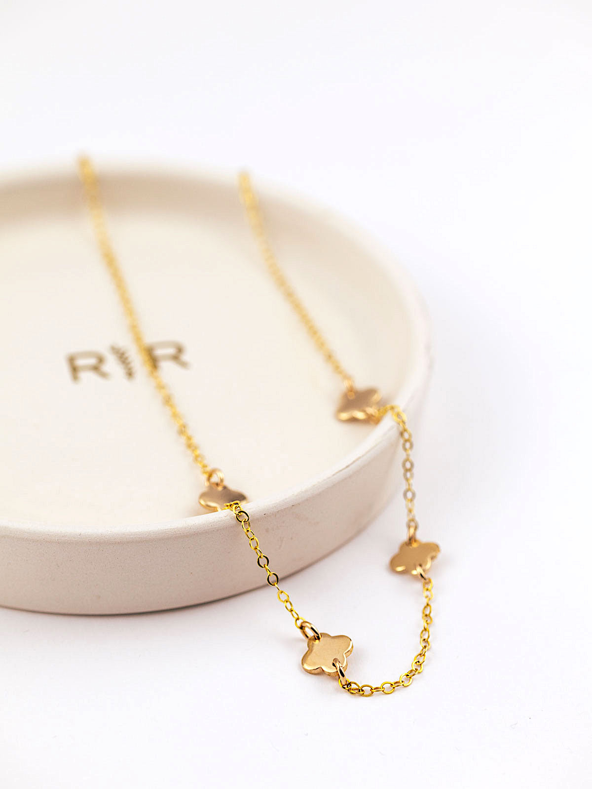 4 leaf clover pendants necklace in gold on jewellery dish