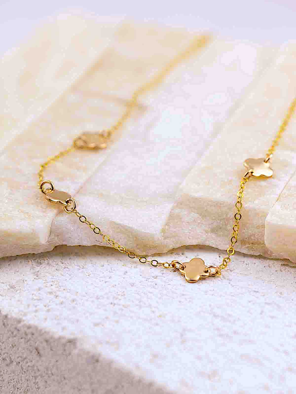 4 leaf clover pendants necklace in gold on brick background
